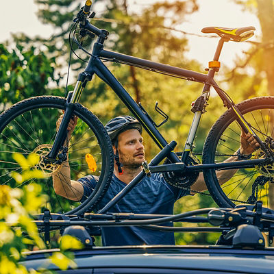 A man positions his bike on a rooftop bike rack 