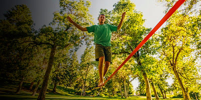 A man slacklining in a park in Bozeman, Montana.