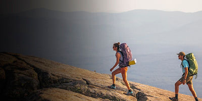 Two people hike on a backpacking trip to Mount Mansfield, New Hampshire