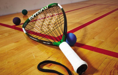 Racquetball and racquet on a court. 