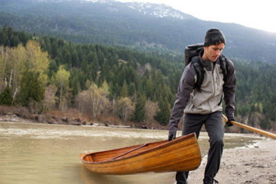 Man dragging a canoe out of the water. 