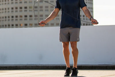 Man jumping rope on a rooftop in a city