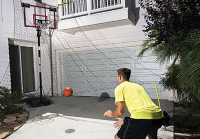 Man waiting for a ball to roll down from his basketball return net