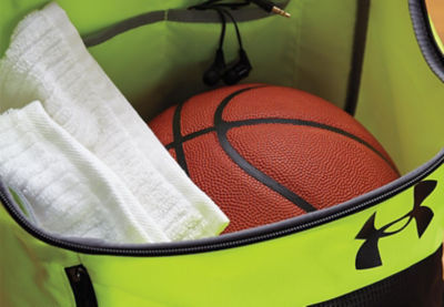 Basketball tucked away in gym bag next to a towel