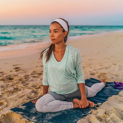 A woman on a yoga mat stretching 