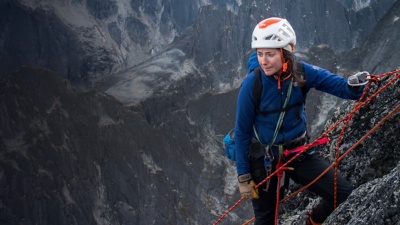 Mo Beck looks on as she rock climbs