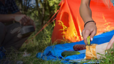 Campers cutting bread with a camping knife