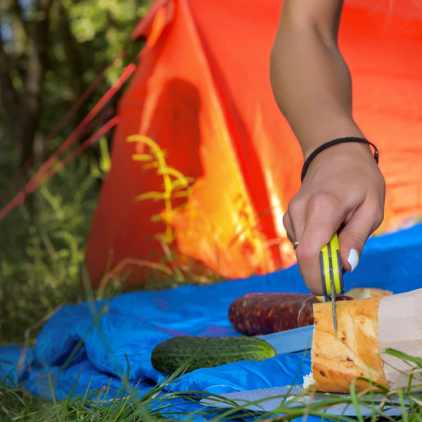 Campers cutting bread with a camping knife
