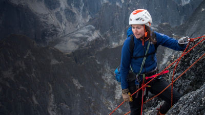 Mo Beck looks on as she rock climbs