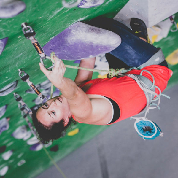 Mo Beck climbs on an indoor rock wall