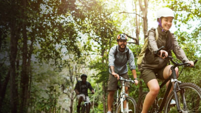 Group of friends ride mountain bike in the forest together