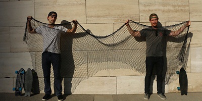 Two men hold up fishing nets