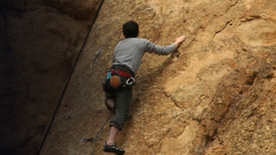 A climber climbs on volcanic tuff