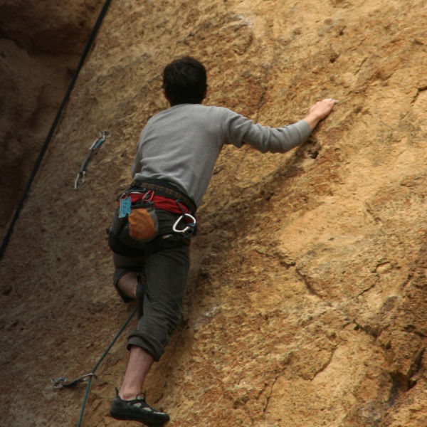 A climber climbs on volcanic tuff