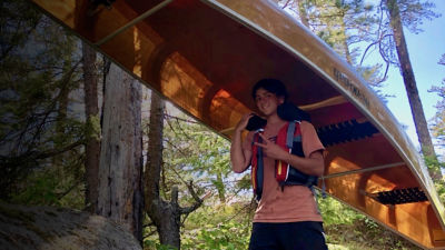 Joseph Goldstein walks with a canoe in the Boundary waters