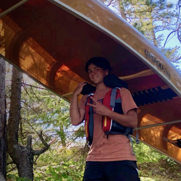 Joseph Goldstein walks with a canoe in the Boundary waters