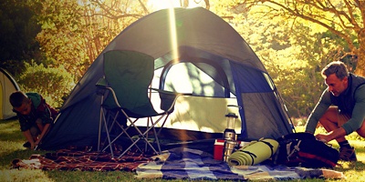 Boy setting up the tent at campsite