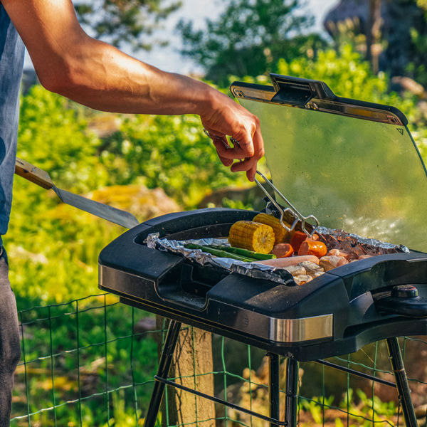 Man preparing food on summer day with electric grill