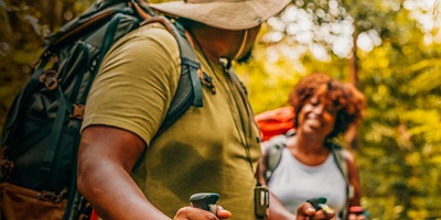 Two people trekking in the forest together