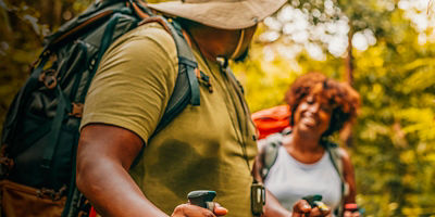 Two people trekking in the forest together