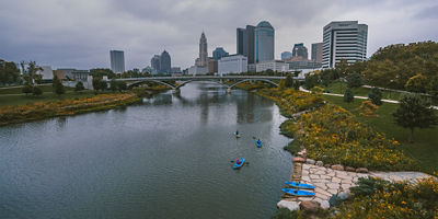 Kayakers exiting launch onto river in front of Columbus skyline