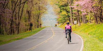 A woman cycling on a road in Shenandoah National Park