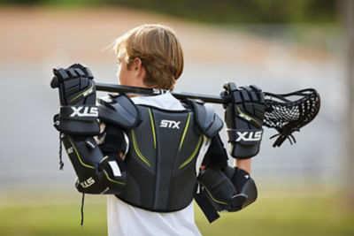 Youth boy wearing lacrosse protective gear.