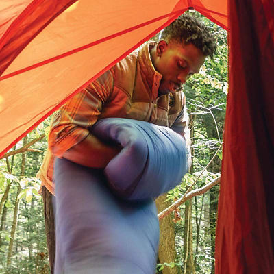 Camper folding a puffy sleeping bag