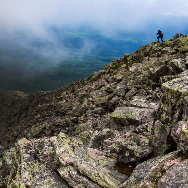 A hiker on the knifes edge of Mount Katahdin in Katahdin Woods and Waters 