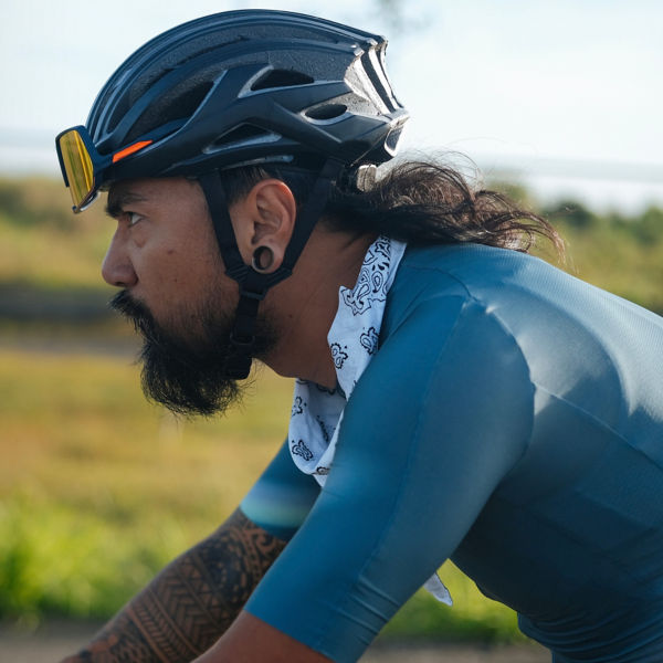 A bearded cyclist in a jersey riding his gravel bike