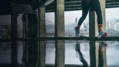 A close up of a runner through puddles