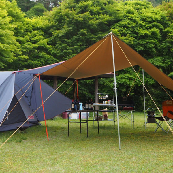 A tent and camp tarp is seen over an eating area