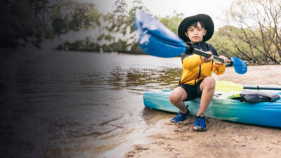 A kid plays with a kayak paddle