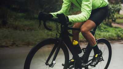 A cyclist riding a bike with a detail on tights