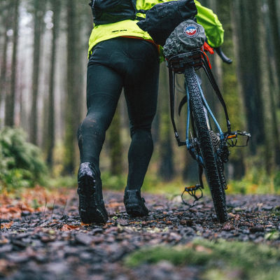A man walking his bike with cycling tights