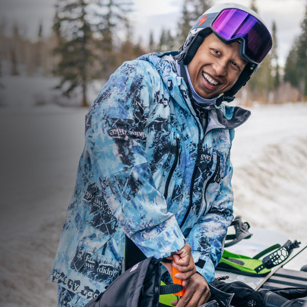A man fixes his snowboard bindings