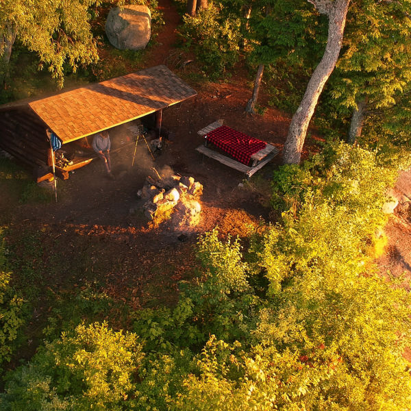 Aerial drone view of Lean to Campsite in the Adirondack mountains with a campfire burning.