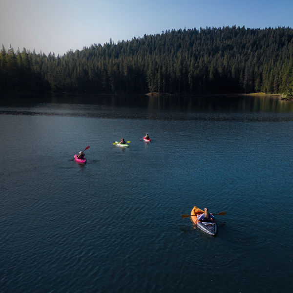 Group of friends kayaking Willow Lake in Southern Oregon on a summer morning