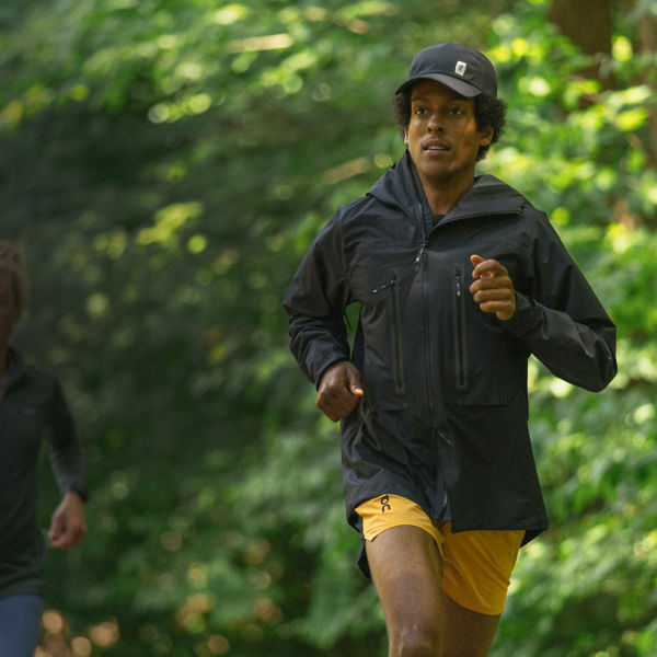 Two runners running on a trail in the forest