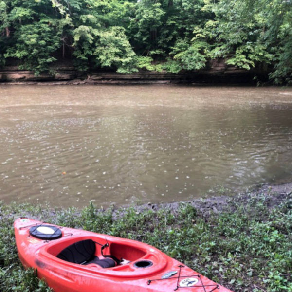 A kayak on the shore of the river at Sycamore Run Park.