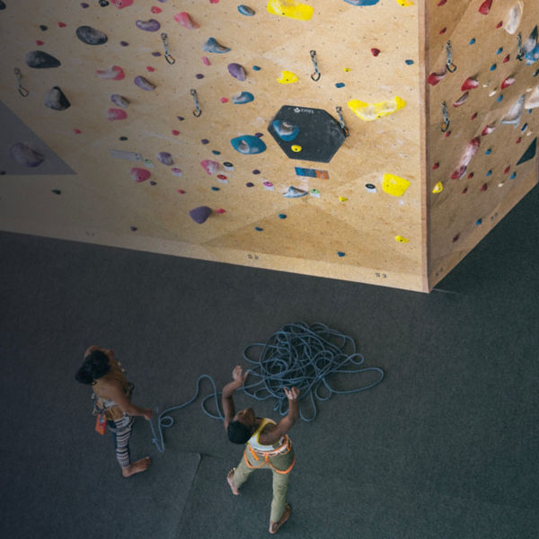 Two climbers look up at a indoor rock wall 