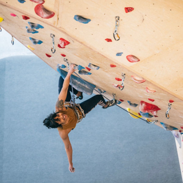 A lead climber on an indoor rock wall