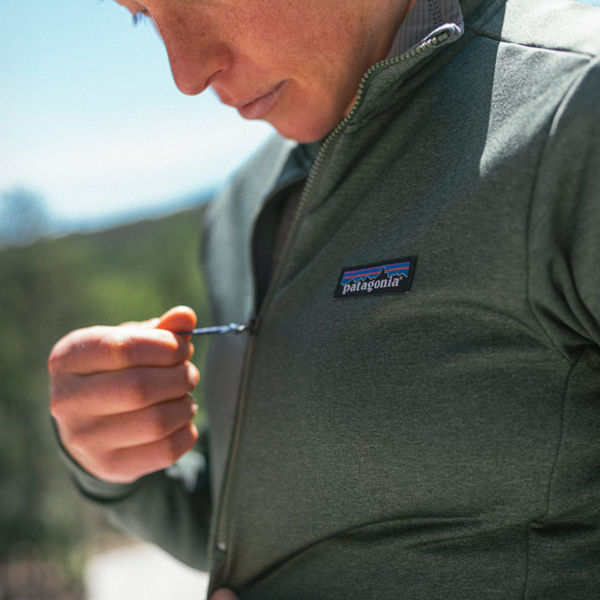 A woman zips up her jacket