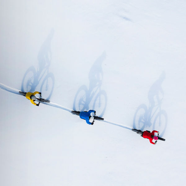 Aerial photo of a group of friends riding their fat bike in the snow 