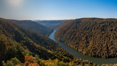 View up the Cheat River in narrow wooded gorge in the autumn.