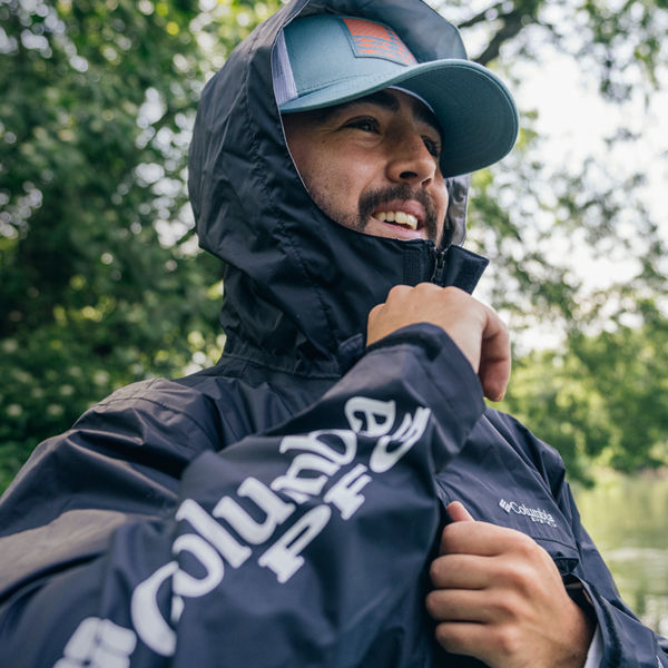 A man zips up his fishing jacket