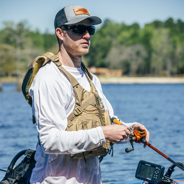 A man wears a vest while fishing