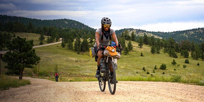 Brooke Goudy smiles as she rides her bike on a road