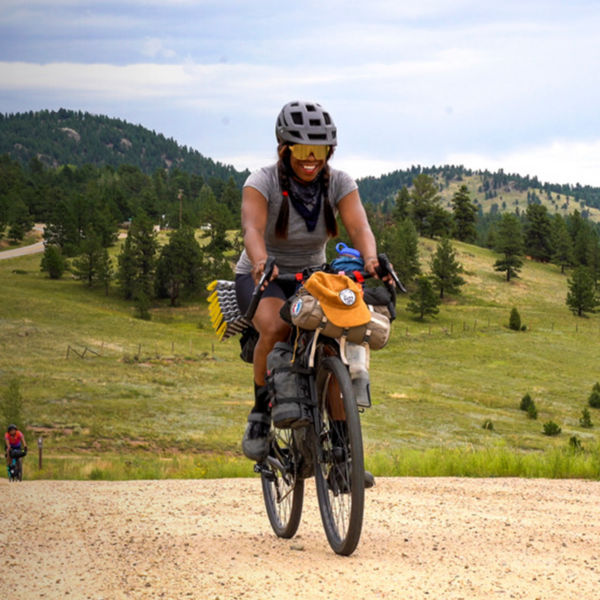 Brooke Goudy smiles as she rides her bike on a road