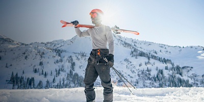 A man looks ahead in snowpants with ski gear